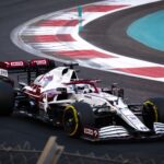 Dynamic shot of a Formula 1 car racing on a modern track during the day.