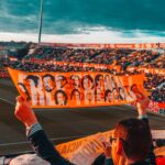 Energetic crowd at Girona FC stadium holding a vibrant banner during a football match.