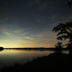 Star-filled night sky reflected on a tranquil lake in Elberton, Georgia.