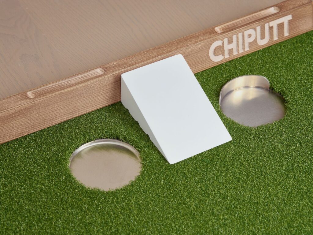 Enhance your golf skills with this innovative chip and putt training aid featuring artificial turf and multiple practice holes.