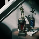A collection of soccer and baseball trophies displayed indoors, capturing childhood nostalgia.