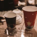 Disposable holiday-themed coffee cups on a table, perfect for seasonal drinks.