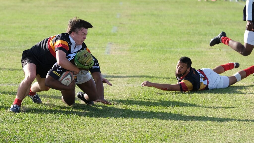 Intense rugby action with players tackling during a match in South Africa.