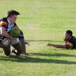 Intense rugby action with players tackling during a match in South Africa.
