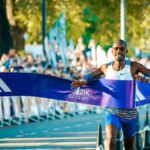 Male athlete crossing the finish line at the Buenos Aires marathon in a lively outdoor event.