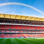 Stunning view of Wembley Stadium, England's iconic football venue, under clear blue skies.
