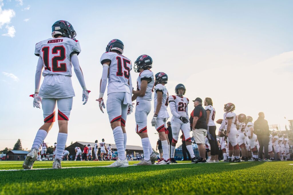 A high school football team lines up on the field, ready for their match.