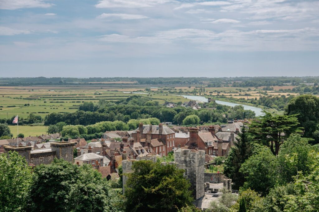 A scenic aerial view of Arundel with lush countryside, river, and historic architecture.