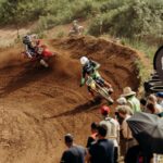 High-speed motocross action on a dirt track in Schaafheim with an enthusiastic crowd watching.