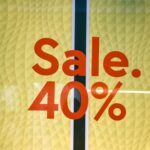 Bright retail sale sign showing 40 percent discount on yellow background.