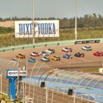 High-speed NASCAR race on a sunny day at the iconic Miami speedway track.