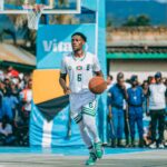 Basketball player dribbles outdoors during a vibrant community game.