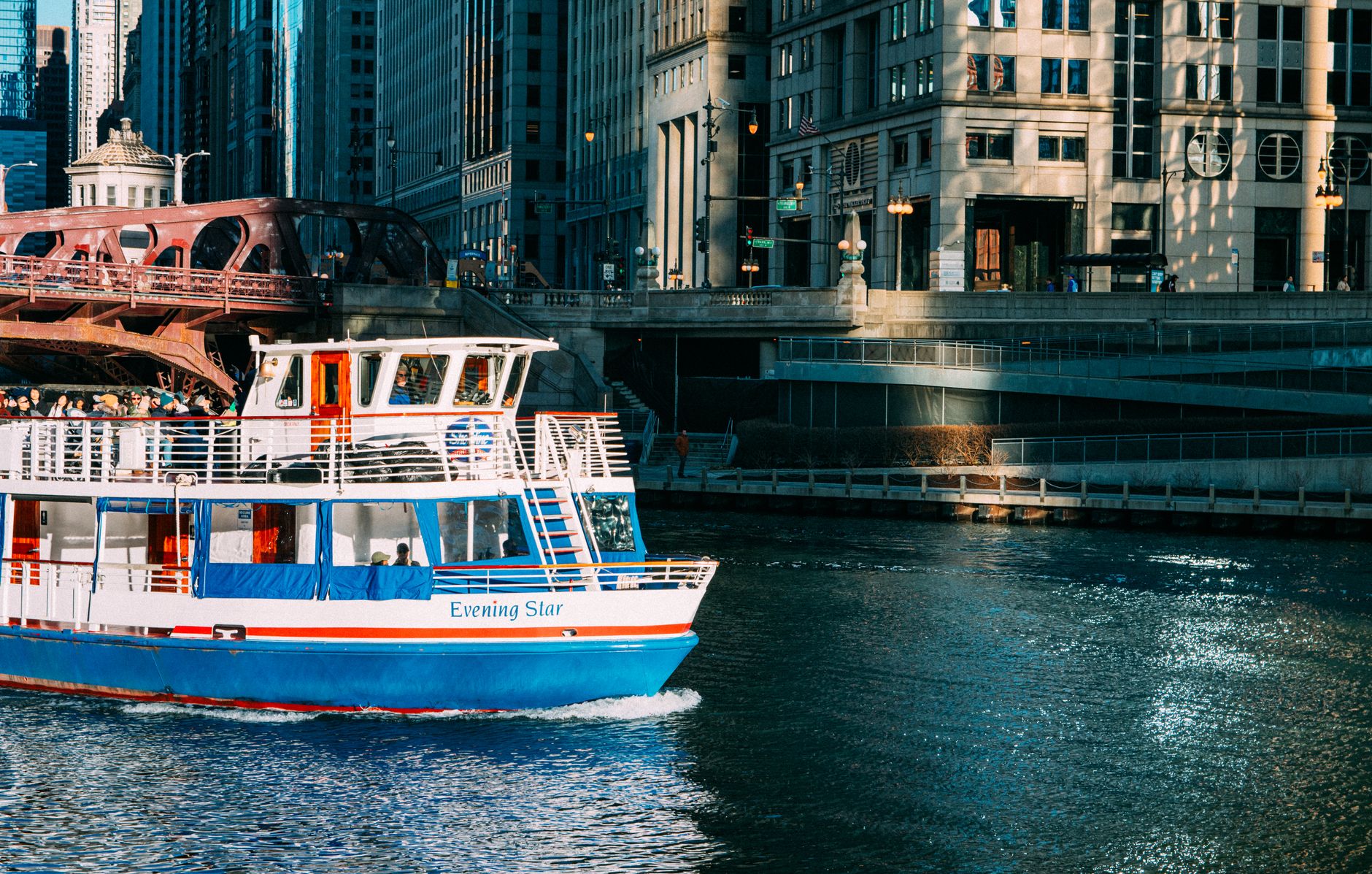 Tour boat cruising the Chicago River against a backdrop of urban architecture.