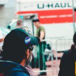 Participants at a political rally in Wheeling, WV wearing campaign merchandise with a U-Haul in the background.