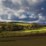 Beautiful rural landscape with rolling hills and fields under a dramatic sky in County Durham, UK.