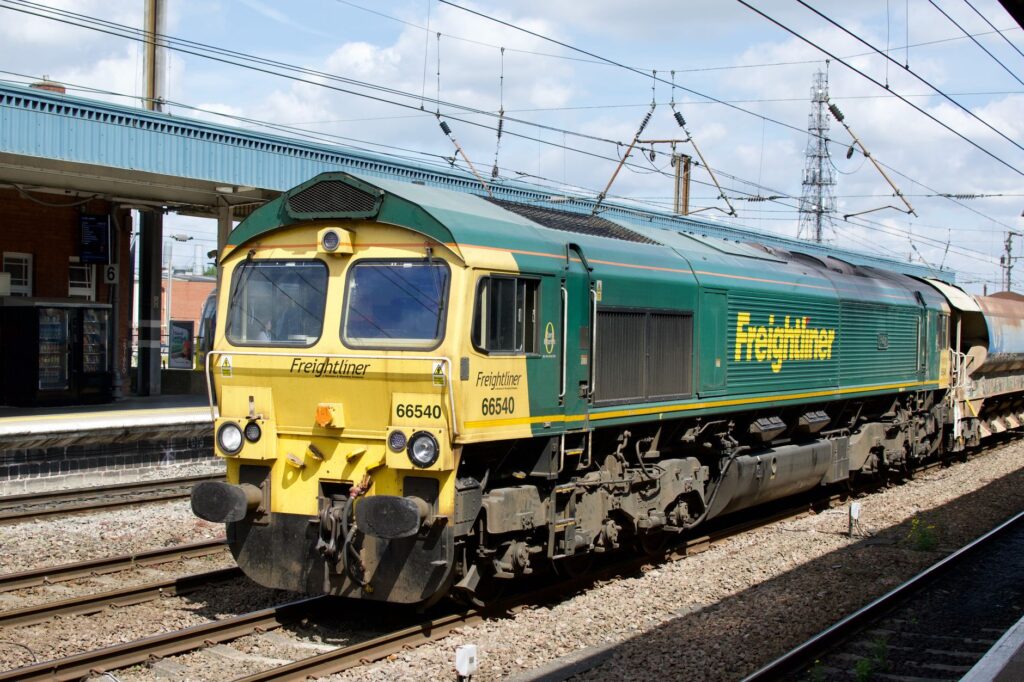 Freightliner locomotive at train station during daytime, showcasing modern rail transport.