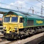 Freightliner locomotive at train station during daytime, showcasing modern rail transport.