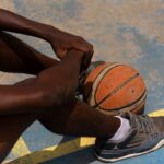 Close-up of a basketball player sitting on an outdoor court in Ado Ekiti, Nigeria.
