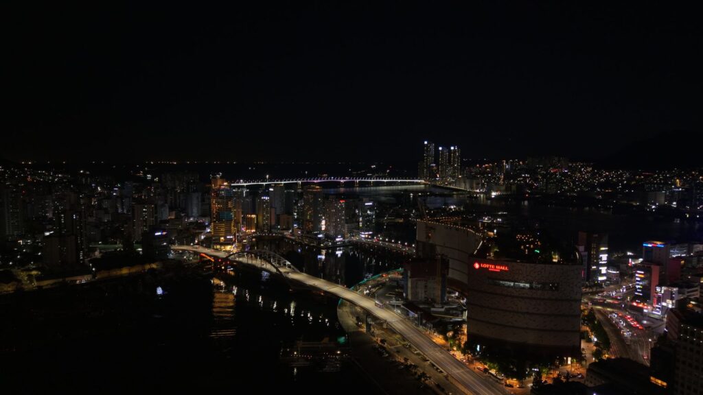 A stunning view of Busan skyline at night with Gwangan Bridge illuminating the cityscape.