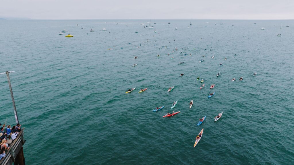 An aerial shot of vibrant kayakers paddling near Newport Beach Pier, California.