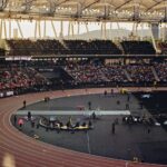 Packed arena scene showcasing a thrilling javelin event under twilight skies.
