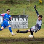 Action-packed soccer moment with goalkeeper making a dramatic save on the field.
