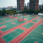 Aerial shot of multiple basketball courts in a residential area of Jiujiang, surrounded by skyscrapers.