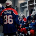 Young ice hockey players in a locker room getting ready, showcasing team spirit and preparation.