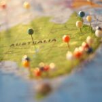 Close-up of a map of Australia with colorful pins marking various cities and destinations.