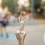 Golden football trophy with ribbons on display, capturing the essence of victory and sportsmanship.
