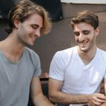 Two friends enjoying a moment of laughter together while seated outdoors in Barcelona.