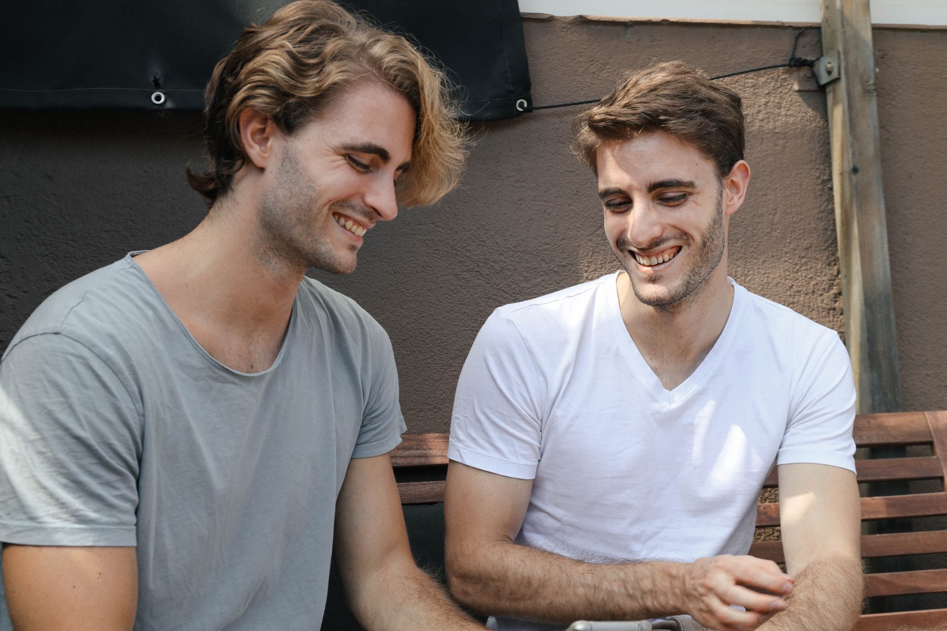 Two friends enjoying a moment of laughter together while seated outdoors in Barcelona.