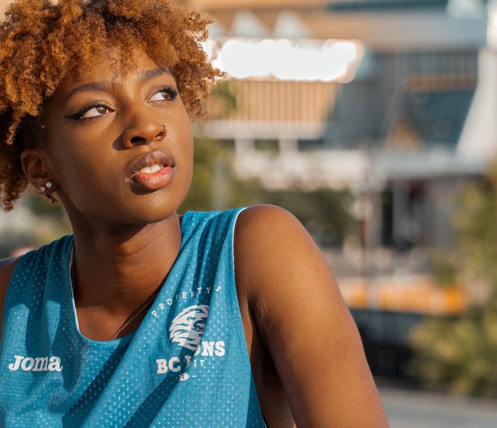 A young woman with afro hairstyle outdoors enjoying a warm summer day.