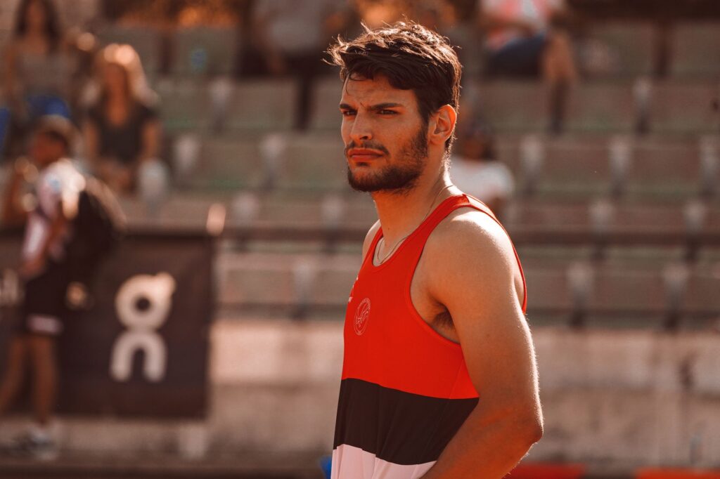 Portrait of a determined male athlete in a sports setting, capturing focused expression and athletic attire.