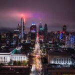 Stunning aerial view of Philadelphia's illuminated skyline at night, showcasing vibrant city lights.