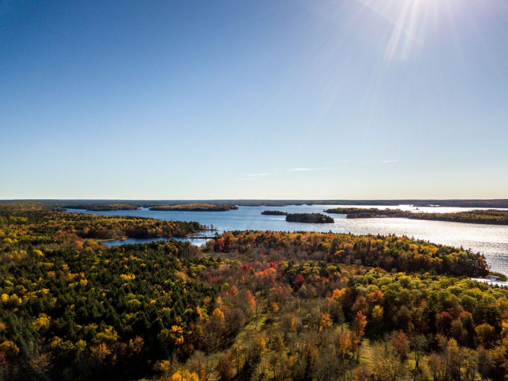 A stunning aerial view of Jakes Landing, Nova Scotia in autumn, showcasing vibrant foliage and serene lakes.