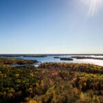 A stunning aerial view of Jakes Landing, Nova Scotia in autumn, showcasing vibrant foliage and serene lakes.