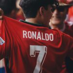 A passionate soccer fan wearing a Ronaldo jersey celebrates at a sports event.