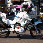Classic Yamaha motorbike with racing decals parked in Lyndhurst, UK on a sunny day.