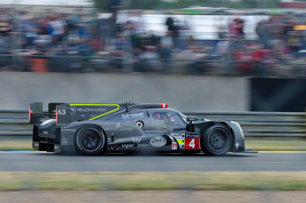Dynamic shot of a racing car speeding on the Le Mans circuit, capturing the essence of endurance racing.
