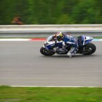 Dynamic shot of a professional motorcycle racer speeding on a track during a competition.
