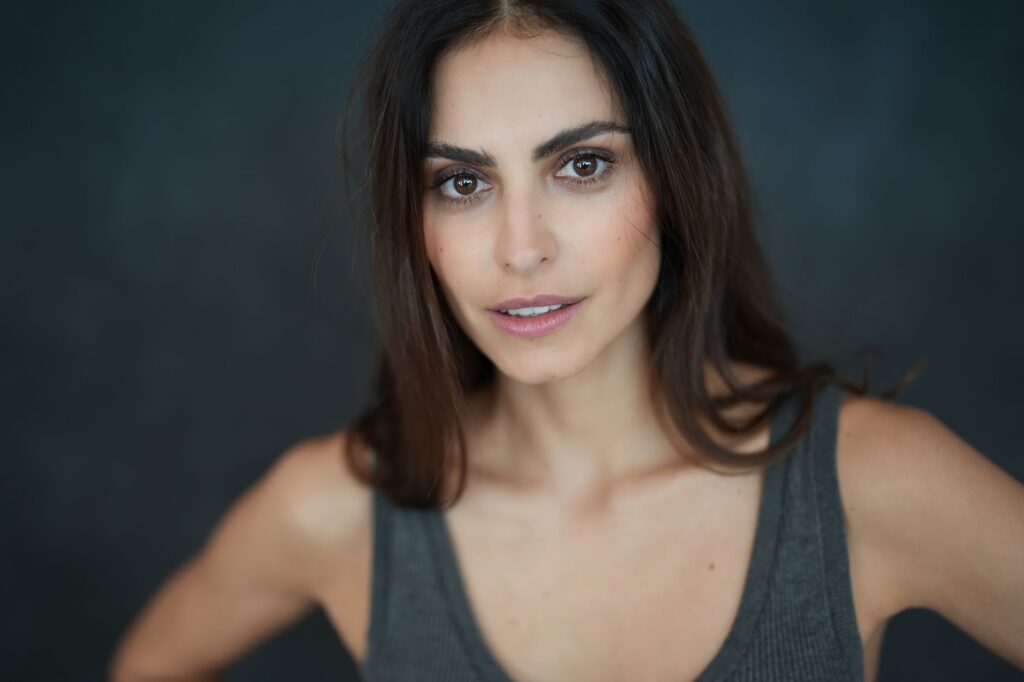 Portrait of a young woman with natural beauty in a studio setting. Soft lighting enhances her elegant features.
