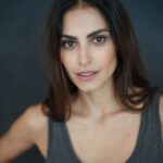 Portrait of a young woman with natural beauty in a studio setting. Soft lighting enhances her elegant features.