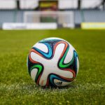 A vibrant adidas soccer ball on a green field, perfect for sports enthusiasts.