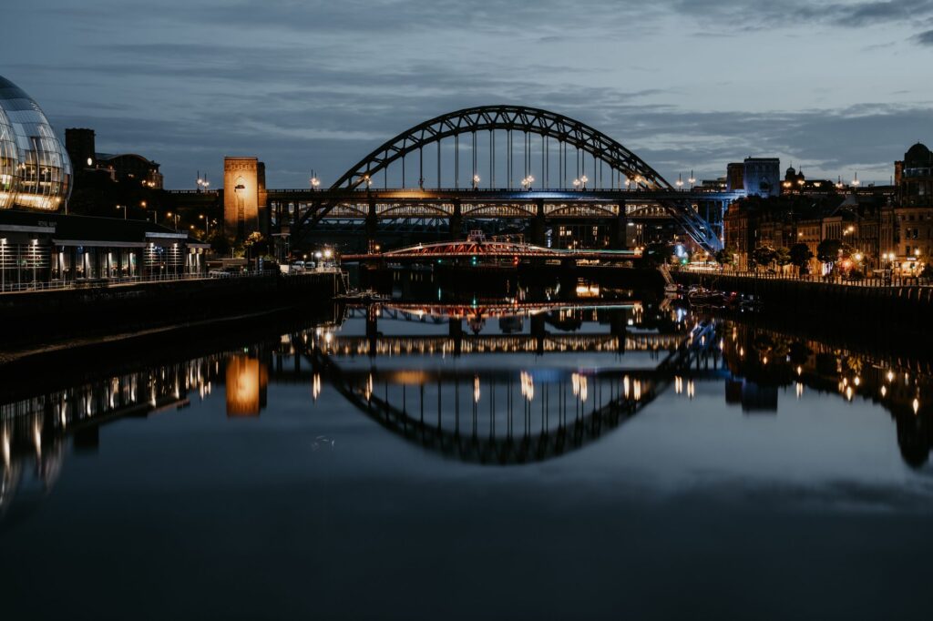 Stunning night cityscape of Newcastle's Tyne Bridge reflecting in the river.