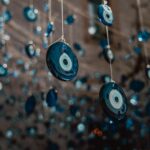 Close-up of numerous blue evil eye charms hanging on strings, capturing tradition and decoration.