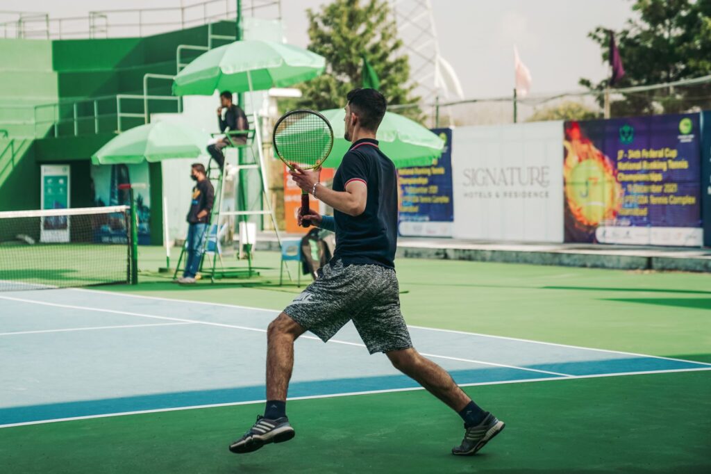 A male athlete playing tennis on a sunny day in Islamabad, Pakistan.