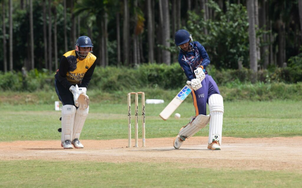 Two cricketers playing an intense match outdoors on a sunny day.