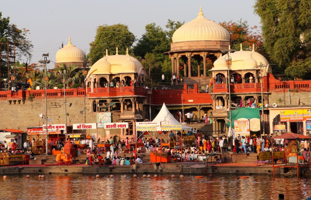 Bustling evening at Ram Ghat with pilgrims and vibrant architecture in Ujjain, India.