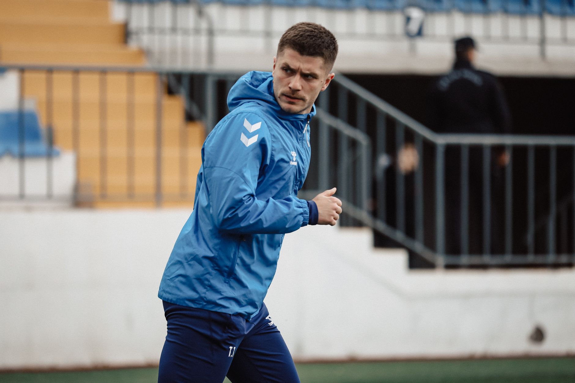 Focused football player warming up on the field in Baku, Azerbaijan, showcasing athletic determination.